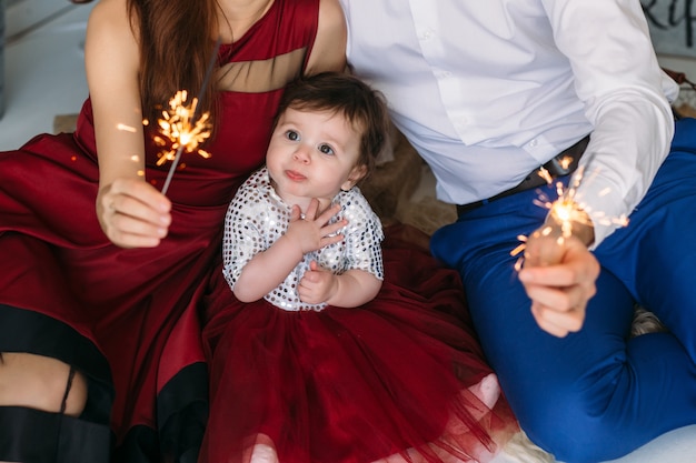 The mother, father and daughter sitting on the floor