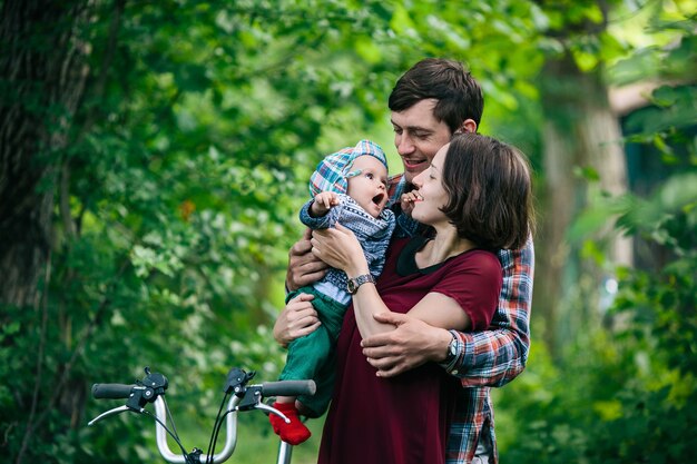 Mother and father holding baby outside