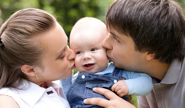 Mother and father kissing their small toddler