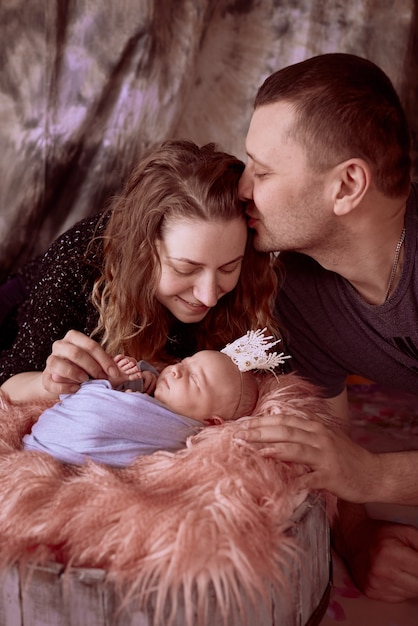 Foto gratuita la madre e il padre seduti vicino a loro figlia