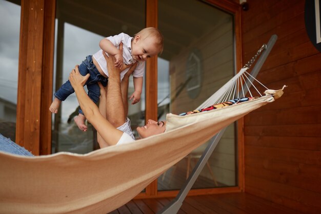 The mother,father and son lie on the hammock