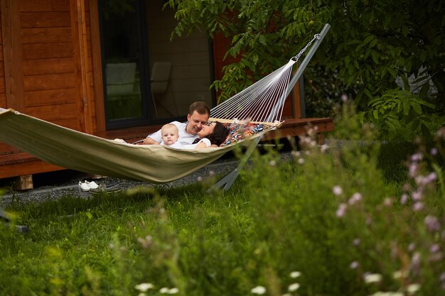 The mother,father and son lie on the hammock