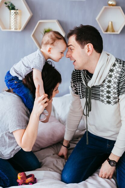 The mother ,father and son sitting on the bed