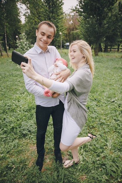 Mother and father taking a picture with their baby