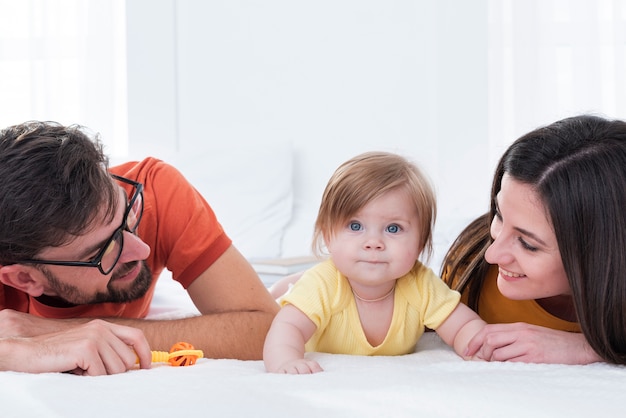 Mother and father with baby in bed