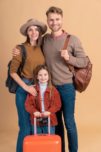 Mother and father with daughter and luggage ready for travel