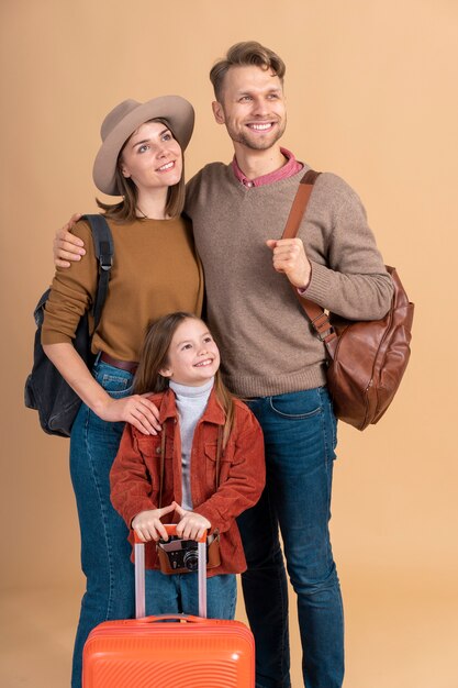 Mother and father with daughter and luggage ready for travel