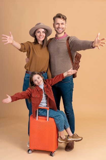 Mother and father with daughter and luggage ready for travel