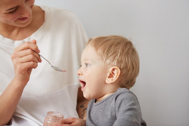 Mother feeding her baby boy with spoon