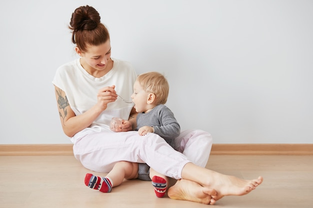 Mother feeding her baby boy with spoon