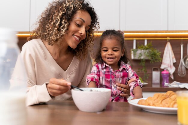 Mother feeding her daughter in the kitchen