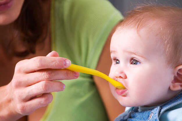 Madre che alimenta il bambino affamato