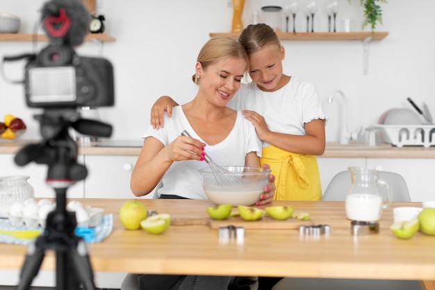 Free photo mother and girl cooking medium shot