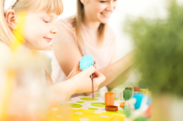 Mother and girl decorating Easter eggs