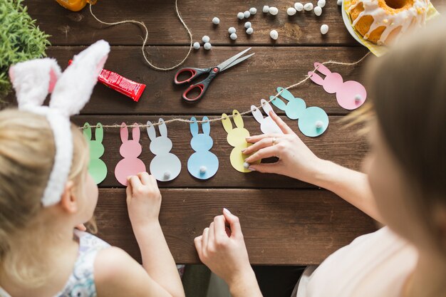 Mother and girl decorating garland