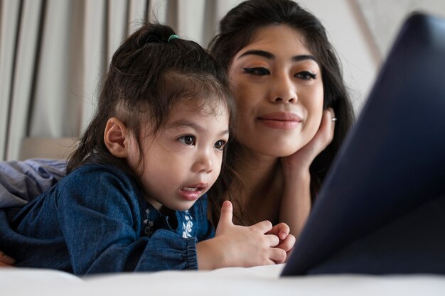 Mother and girl looking at tablet close up