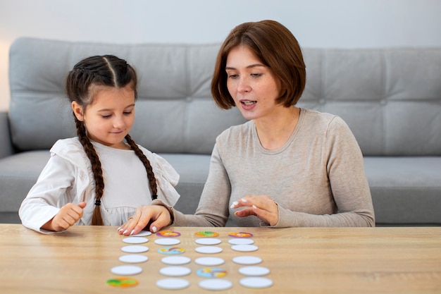 Free photo mother and girl playing game front view