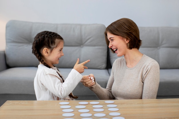 Free photo mother and girl playing game medium shot