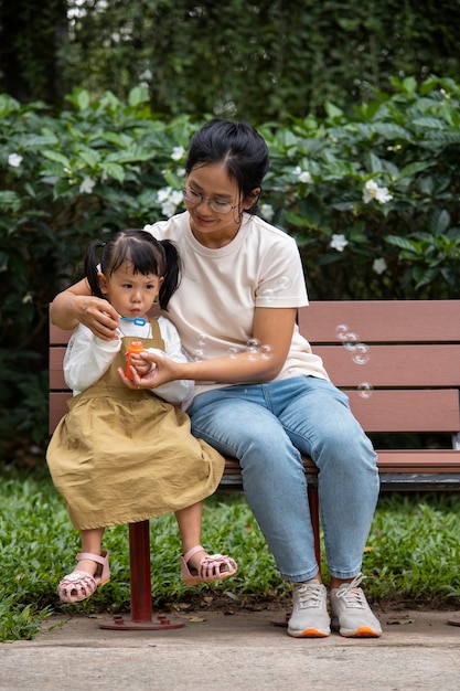 Foto gratuita madre e ragazza che si siedono sulla panchina a tutto campo