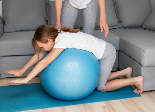 mother and girl sport practice on bouncing ball