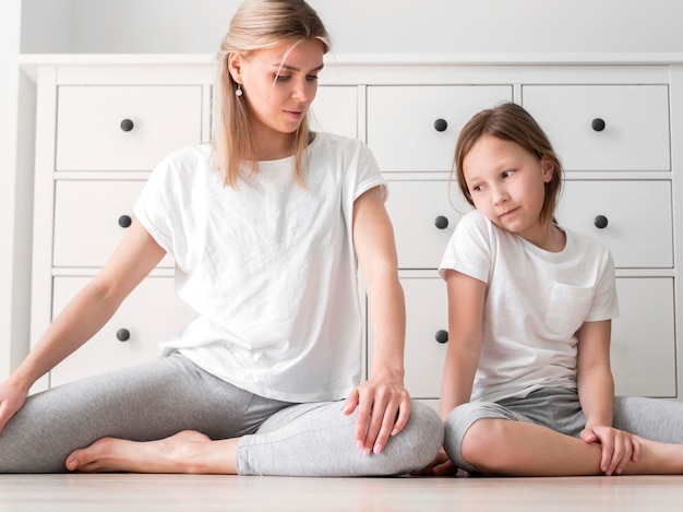 Allungamento di pratica dello sport della madre e della ragazza