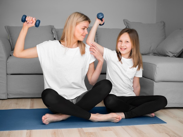 Mother and girl sport training with weights