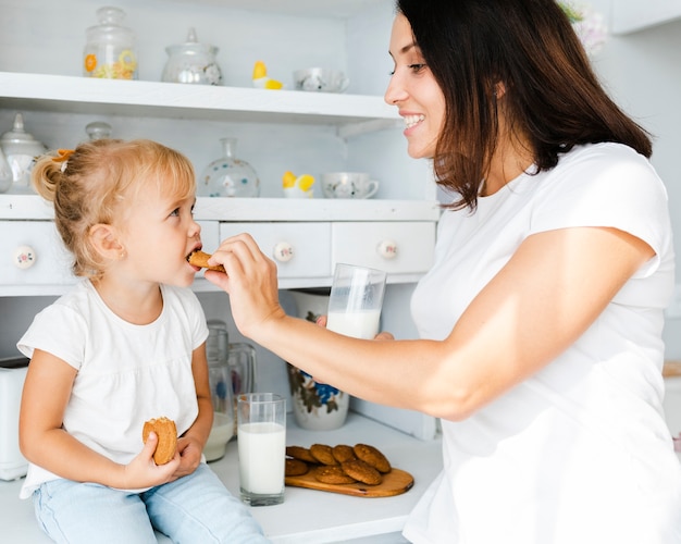 Mother giving a cookie to her daughter