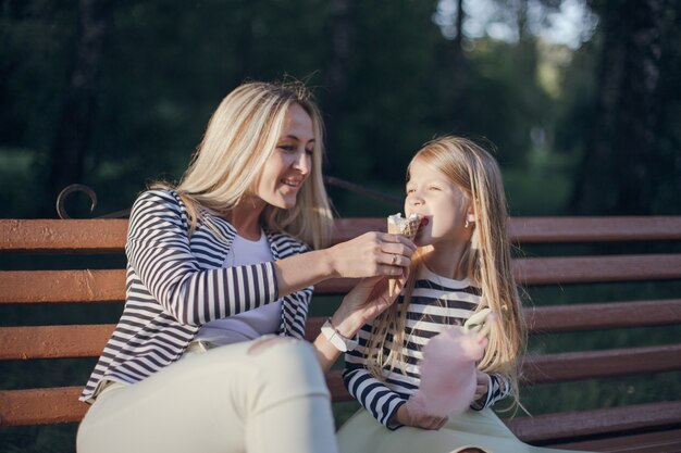 Mother giving her ice cream to her daughter