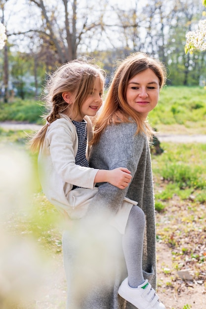 Free photo mother giving piggyback ride to daughter