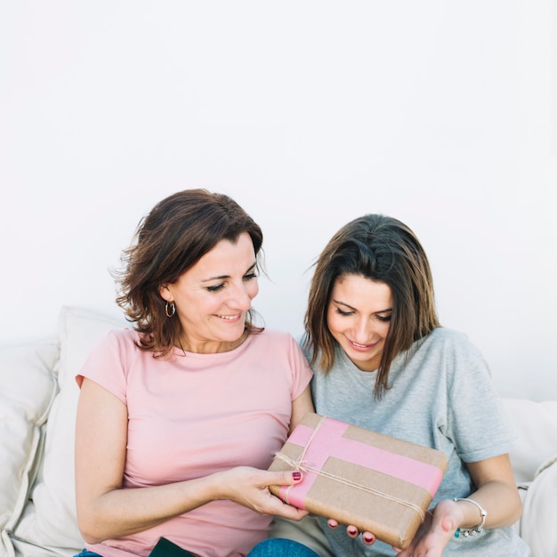 mother giving present to woman at home