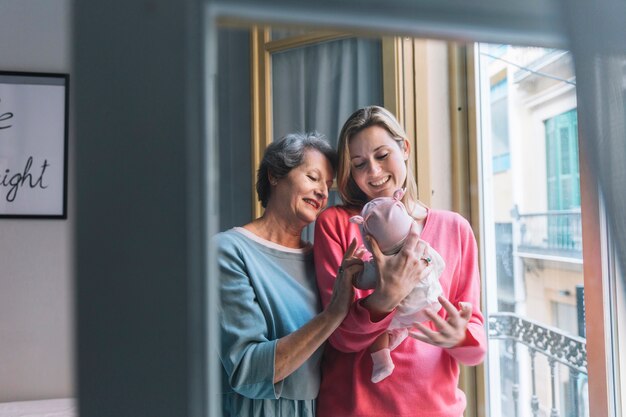 Mother and grandmother looking at baby