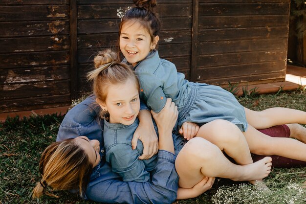 Mother having fun with daughters on grass