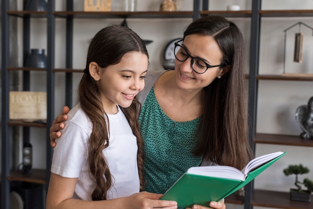 Mother helping girl to read