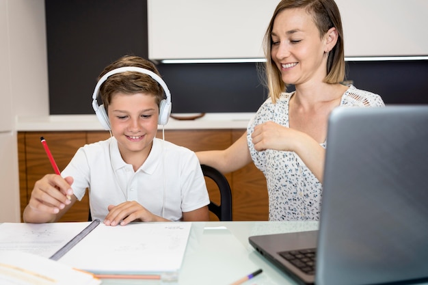 Mother helping her son to finish homework