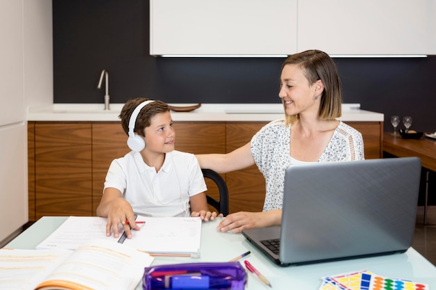 Foto gratuita figlio d'aiuto della madre con i compiti