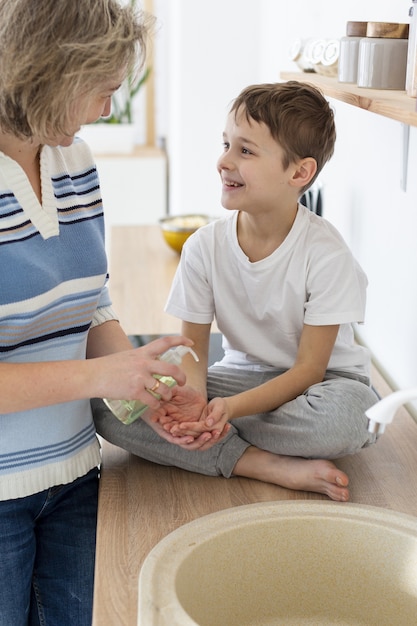 Mother helps child wash his hands