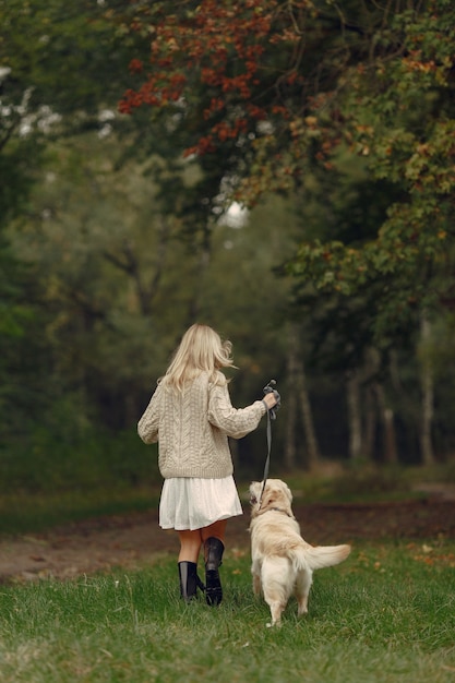 엄마와 강아지와 함께 연주 그녀의 딸입니다. 가을 공원에서 가족. 애완 동물, 가축 및 생활 양식 개념