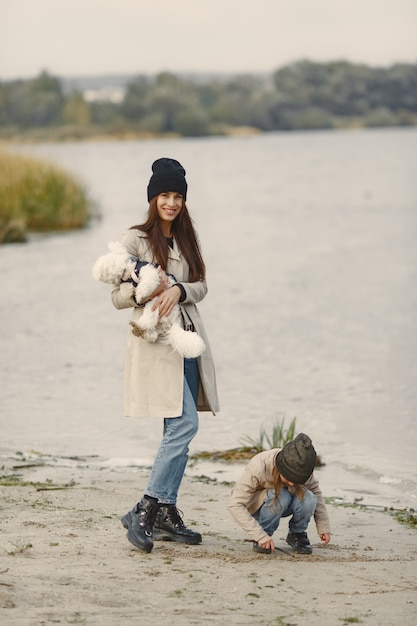 Mother and her daughter playing with dog. Pet, domestic animal and lifestyle concept