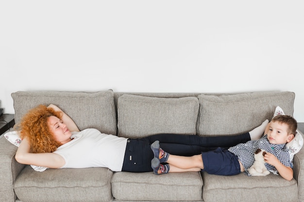 Mother and her son lying on sofa