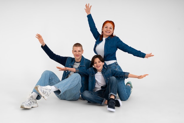 Foto gratuita la madre e i suoi due figli indossano abiti in denim insieme