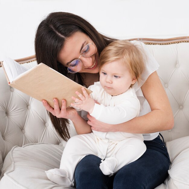 책과 아기를 들고 어머니