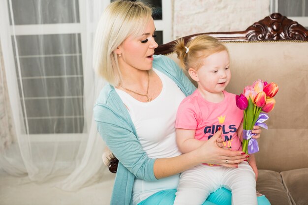 Mother holding daughter with tulips