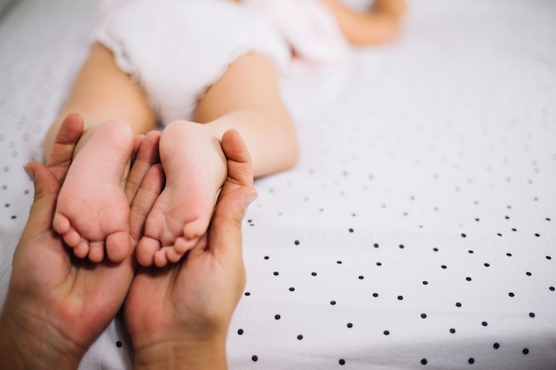 Free photo mother holding feet of baby