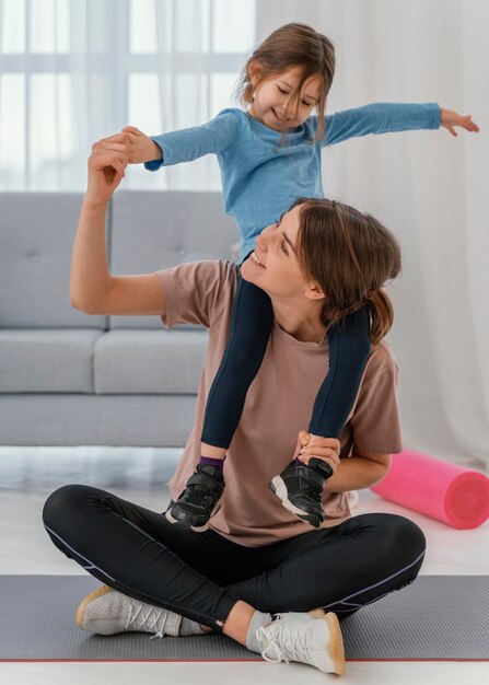 Mother holding girl on shoulders