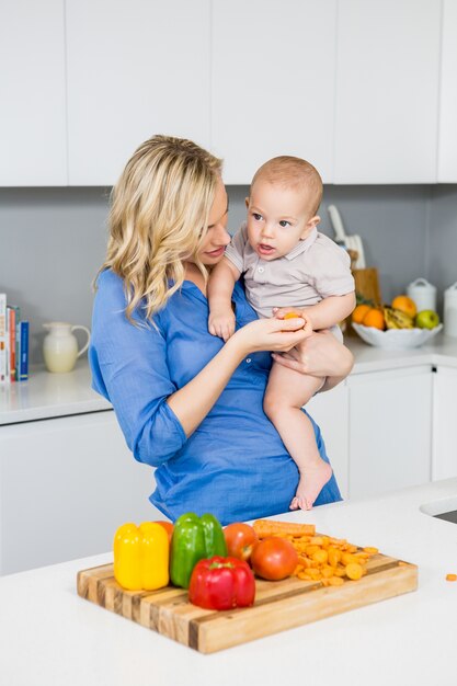 Mother holding her baby boy in kitchen