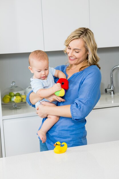 Mother holding her baby boy in kitchen