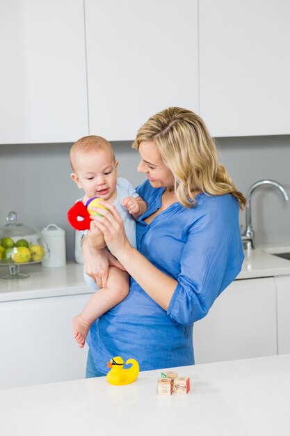 Mother holding her baby boy in kitchen