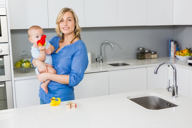 Mother holding her baby boy in kitchen