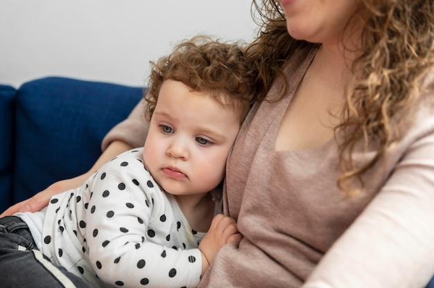 Mother holding her little child on the sofa