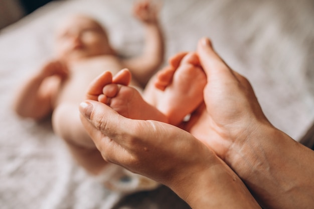 Mother holding newborn baby feet